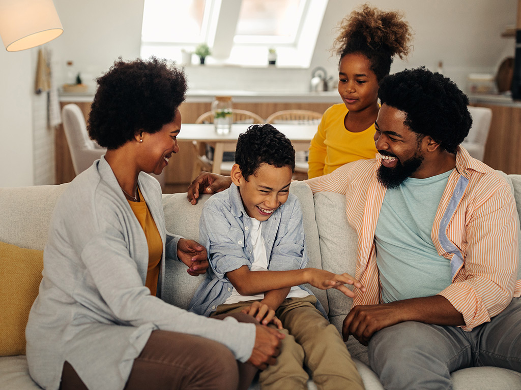 Family laughing on the couch together