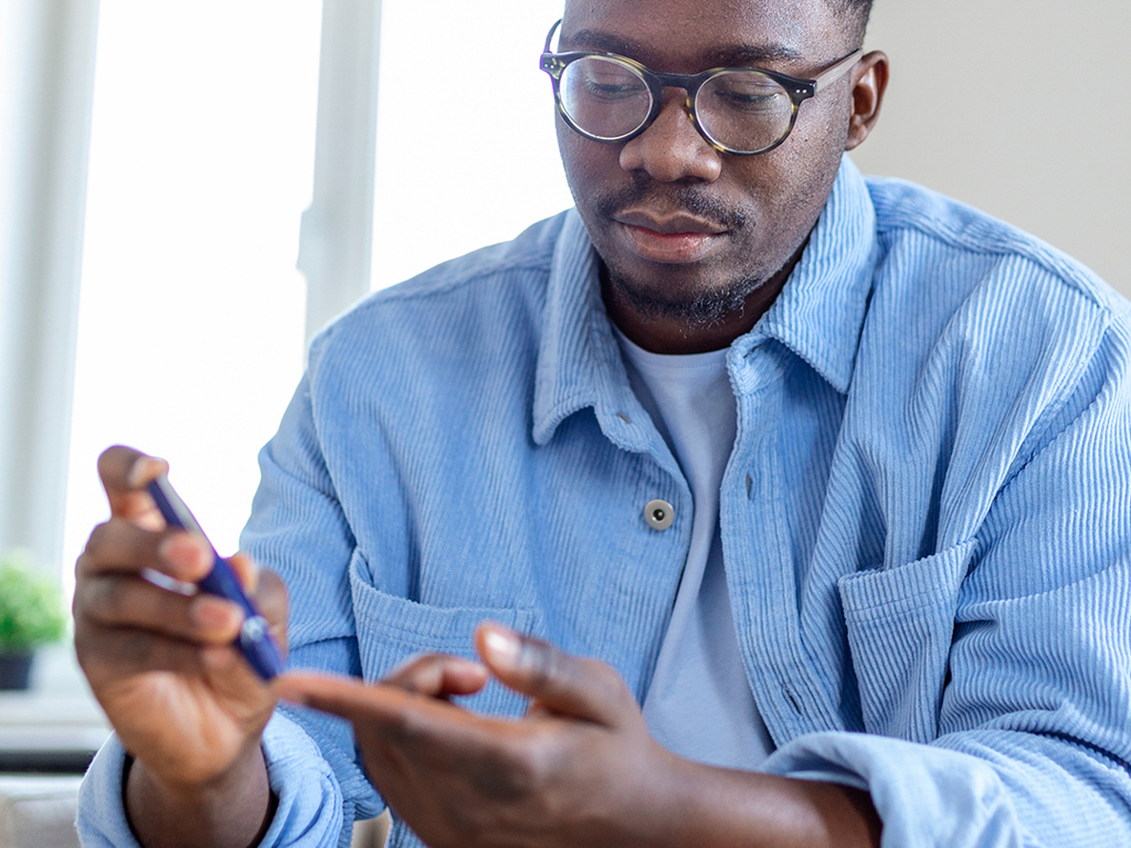 a young man checks his blood sugar 