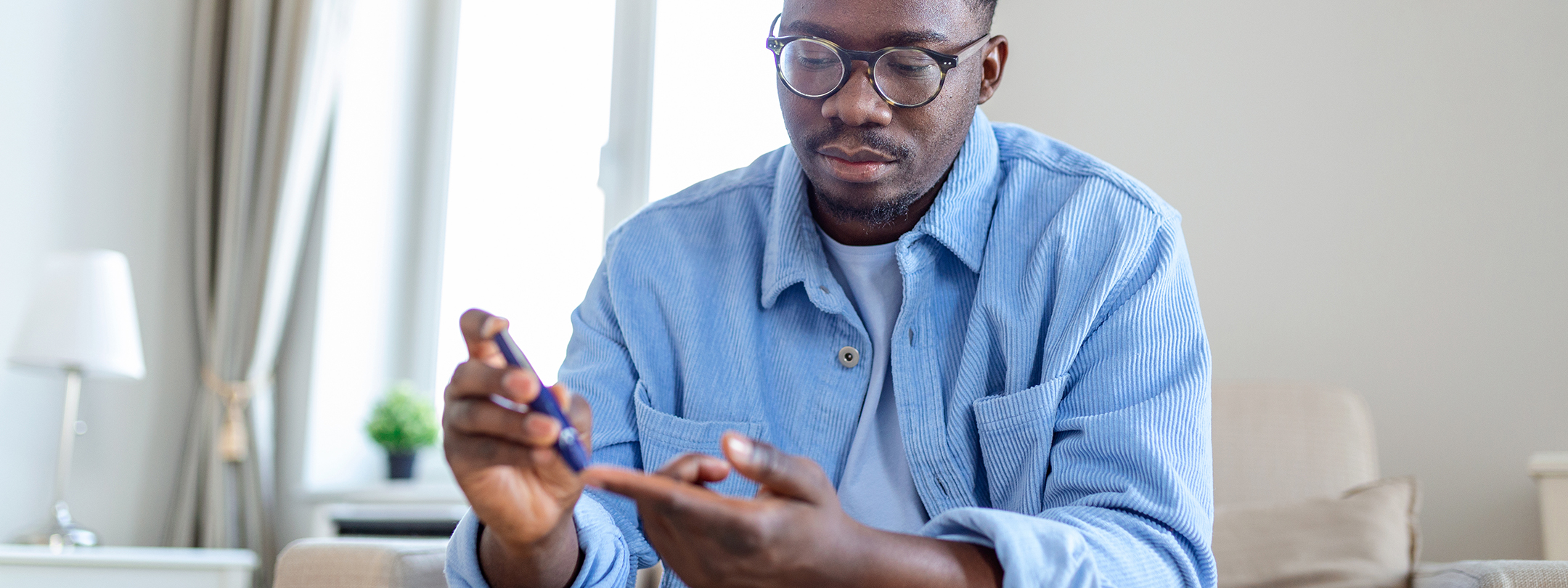 A man is testing his blood sugar on his index finger