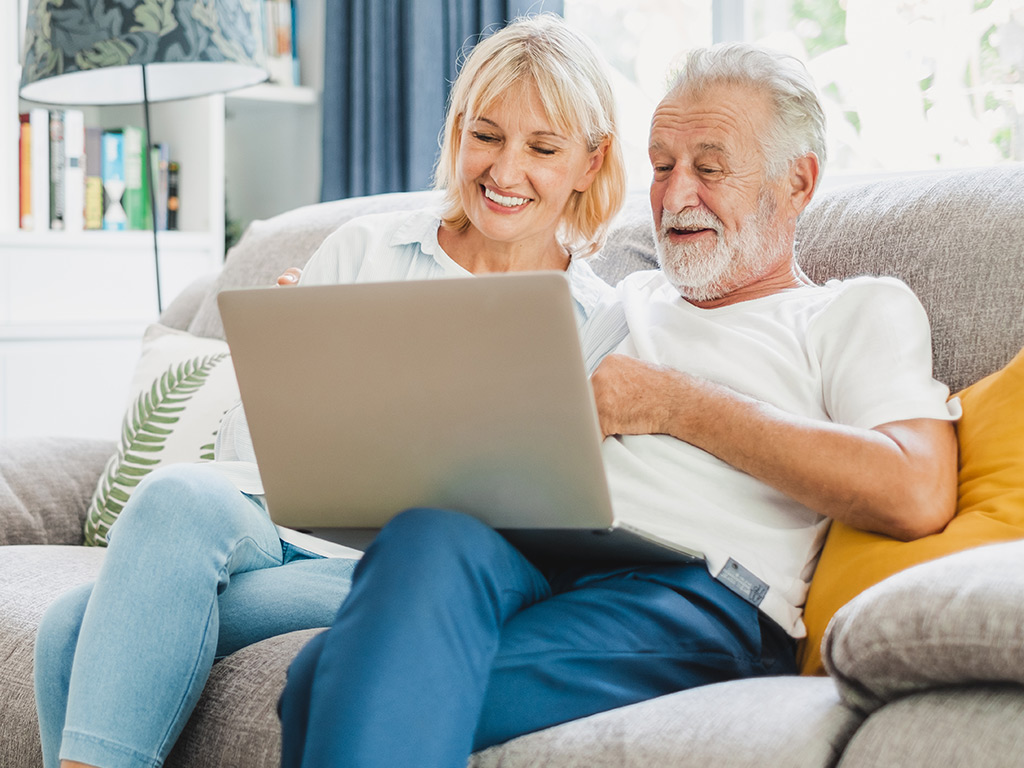 Una pareja de ancianos mirando juntos la computadora.