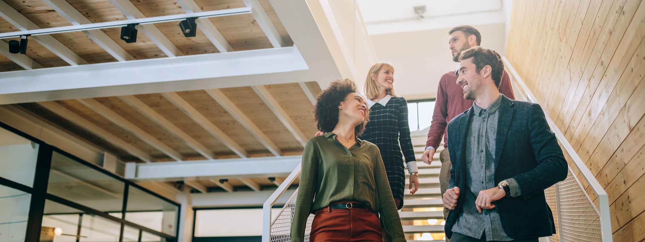 Group of diverse coworkers walking down the stairs in an office