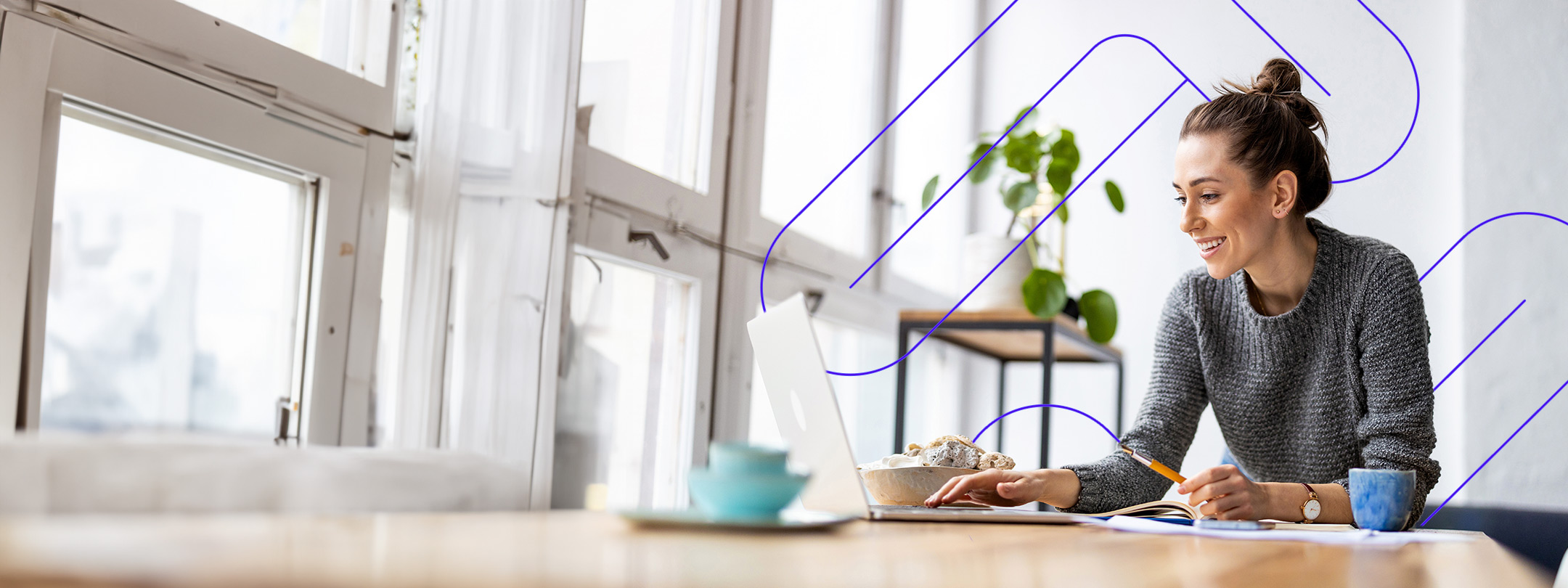 Woman sitting at a desk by windows and working