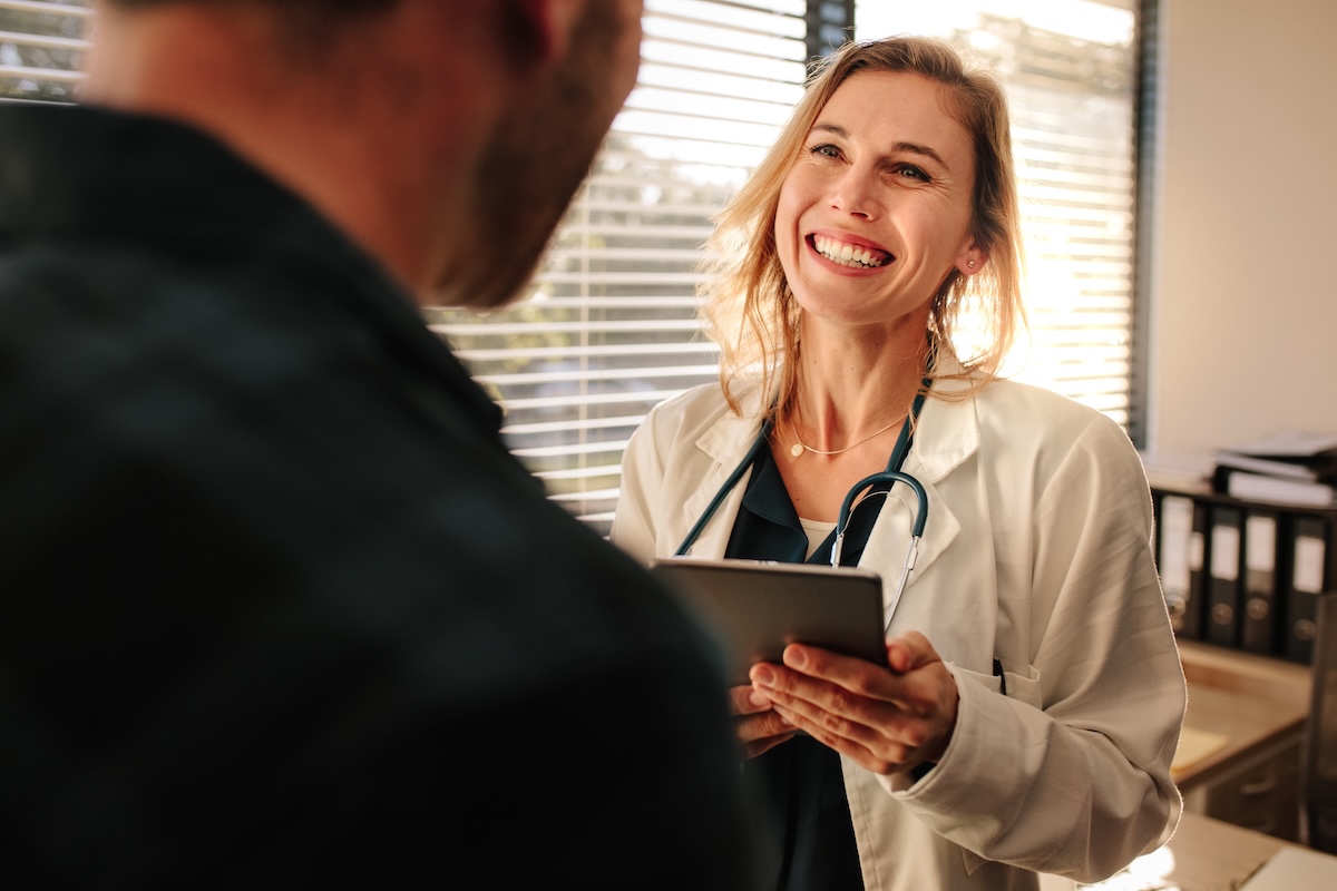 Female doctor consulting a patient in clinic. Smiling female medical professional interacting with a patient.