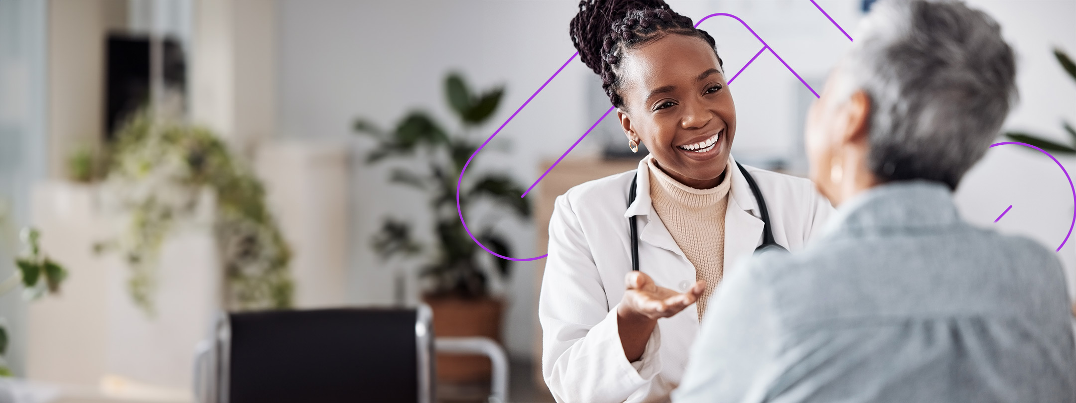 Provider/doctor facing patient and smiling, talking with patient in an office