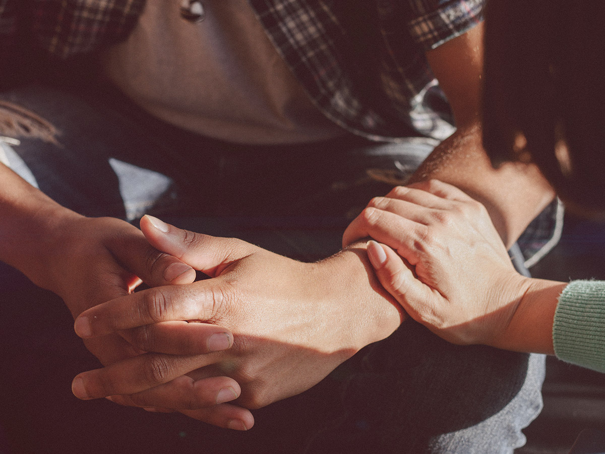 A photo of a personal touching the arm of another in support. 